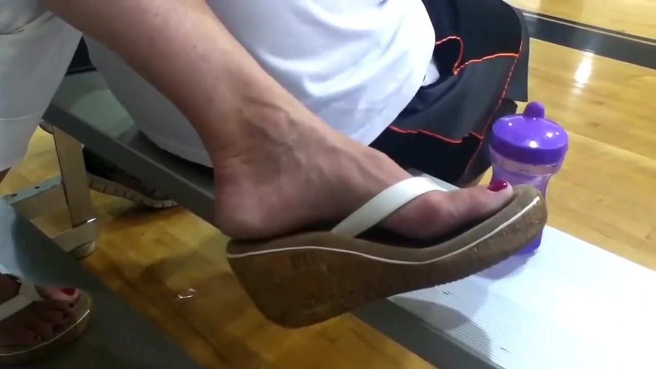 Lady with nice feet dangling flip flops